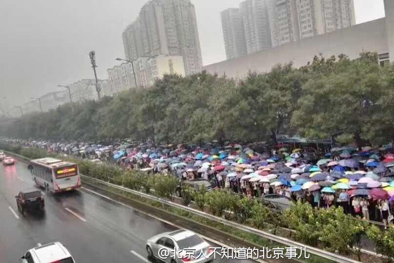 雨天早高峰的北京地铁1号线地铁站外的雨伞